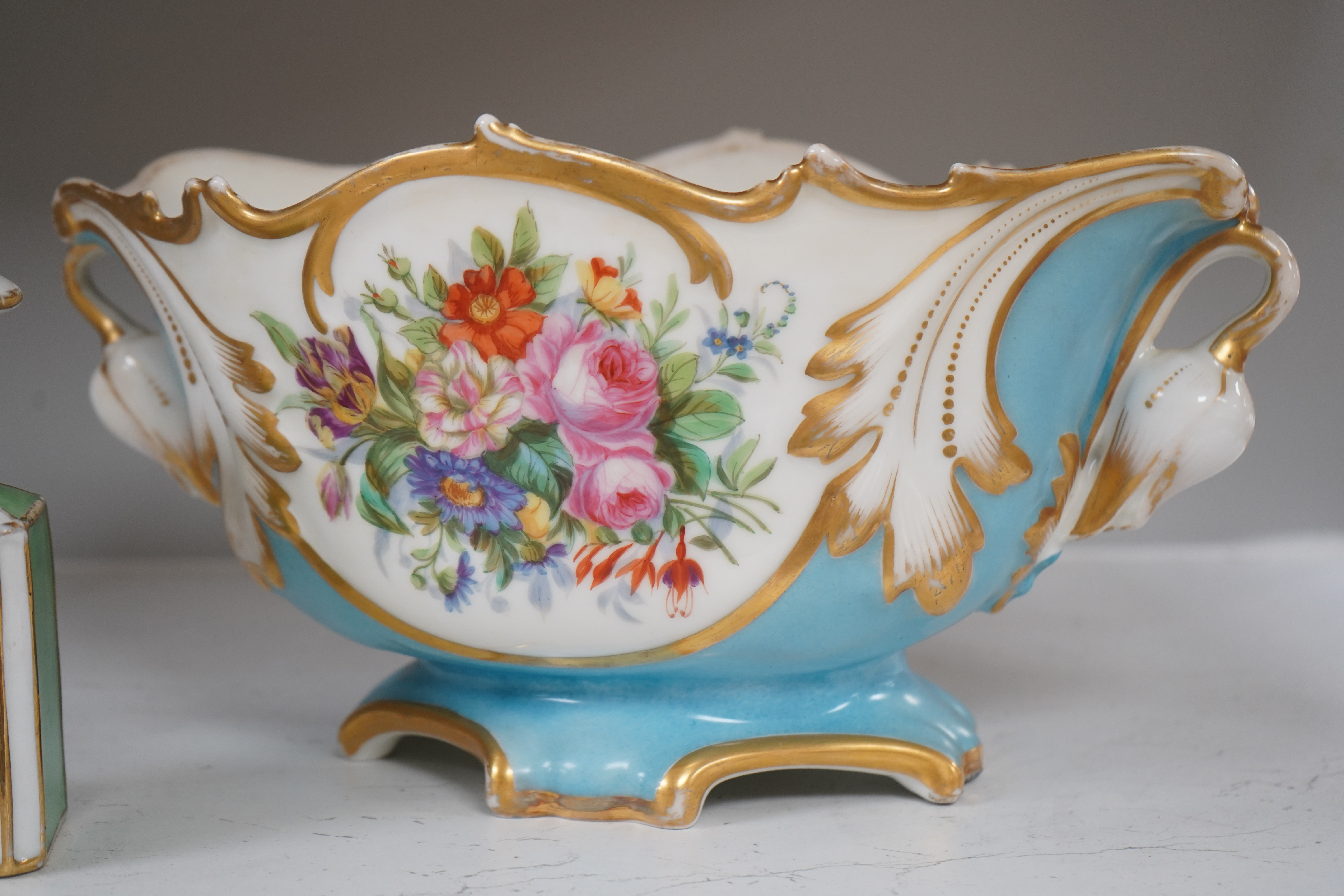 A Sevres style flower painted navette shaped jardiniere and a similar French scent bottle and stopper, late 19th century, largest 38cm wide. Condition - fair to good